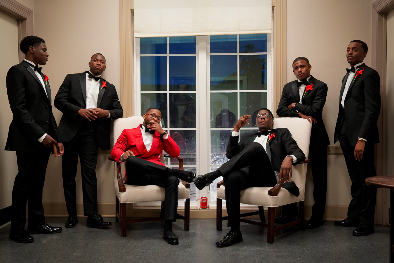 Editorial — men in red and black tuxedos by window