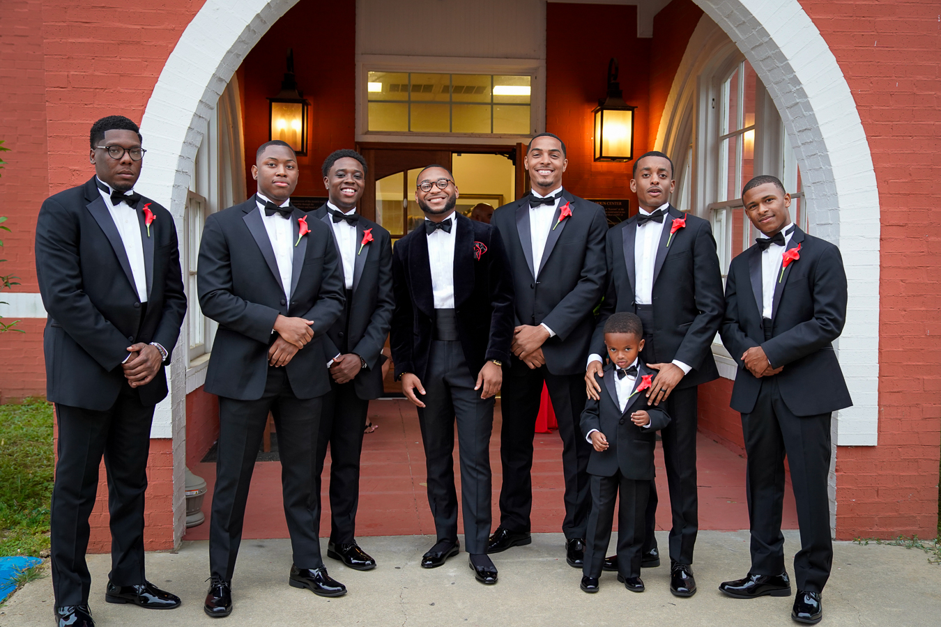 Groomsmen in black tuxedos outside the church
