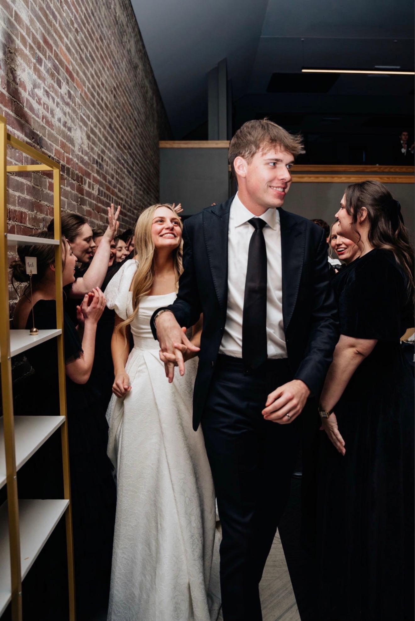 Bride and groom at indoor reception, groom in navy suit