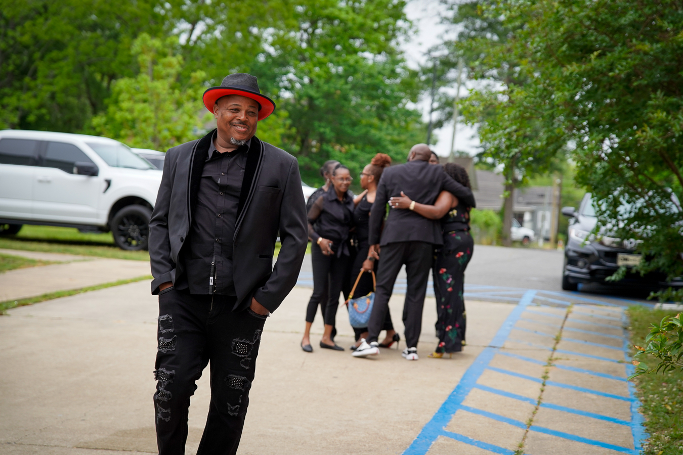 Man in tailored black blazer with red hat