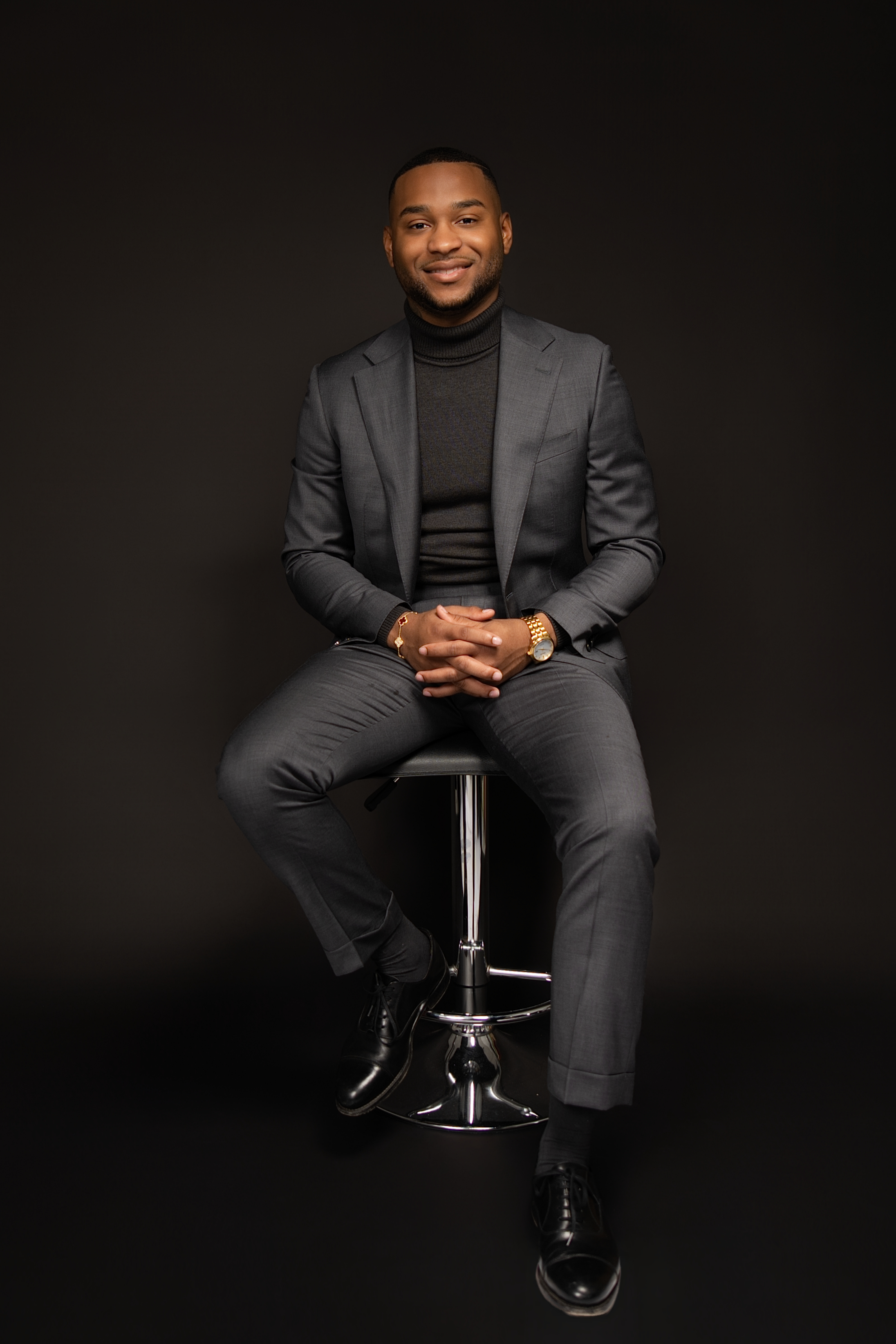 Studio portrait — charcoal grey suit with turtleneck